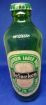 ANTIGA GARRAFA DA CERVEJA " HEINEKEN " CONTEM A TAMPINHA PEÇA MUITO BEM CONSERVADA OBS.: " GARRAFA PEQUENA COM 15,5 cm ALTURA