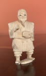 NETSUKE EM MARFIM, representando personagem COM CAIXA . Perda de quatro dedos do pé direito - JAPÃO. MEDIDAS; 5 X 2,5.