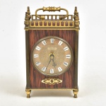 Relógio de mesa Peter Transistor. Mostrador de metal dourado com números romanos, caixa de madeira com cercadura vazada, adornos e pés em metal. Não testado, sem garantias. 18x10x6 cm