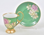 Refinada xícara de porcelana para chá da tarde. Profusa pintura verde com floral cor de rosa e amarelo. Borda e alça em ouro.