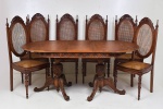 Mesa de jantar (extensora) em cerejeira, tampo oval com saia entalhada de florais, apoiado em par de pés tripoide de folhas e volutas. Acompanha 6 cadeiras no mesmo padrão estilo medalhão com encostos e assentos  de palha. No estado, marcas de uso e tampo da mesa com pequenos folheados a fazer. Mesa 136x87 x78 cm fechada