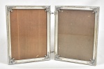 Belíssimo porta retrato duplo em metal prateado, decorado com volutas, guirlandas e perolado.  (26x42)