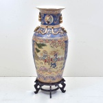 Magnifico jarrão palaciano balaústre, em porcelana chinesa do séc. XX, com fundo azul e relevos a dourado ricamente esmaltado no padrão "Mandarim" ornamentado com medalhões de crianças tocando instrumentos musicais e ladeado por pequenos medalhões com buquê de flores e dama da corte. Acompanha base de  peanha em madeira lacada. Pequeno bicado fio de cabelo na borda.  (91x45)  / base  (21x36)