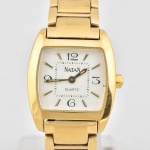Relógio de pulso Natan, mostrador com fundo branco , números e ponteiros em dourado, pulseira de aço com banho de ouro. Caixa 2,5x2 cm. Fundo marcado Modéle Déposé.  Parado, sem garantias
