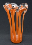 Curioso vaso de grosso vidro, ao gosto Murano, no tom caramelo, decorado com grandes  vazados e com borda recortada. 23 cm alt x  13 cm diam da borda