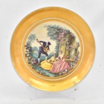 Prato de porcelana européia, medalhão central profusamente decorado com cenas do cotidiano destacado por larga faixa em ouro. Fundo apresenta batido. 26,5 cm diam