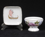 Lote composto por pequena salva em porcelana marca Condessa, Blumenau - com representação do barco de guerra de William the Conqueror 1066 e pequena uveira em porcelana Fine Bone China - Inglaterra, com decoração floral. Alt 10cm  Larg 10cm / Diam 9cm  Alt 6cm