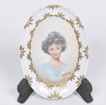 Saboneteira em porcelana Schmidt, pintada à mão com figura de Dama ao centro e borda com margaridas douradas.  Assinada e datada Ma Thereza 78 - Alt 14cm  Larg 10cm