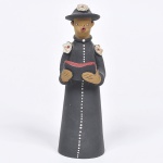 Mestre Adenildo - escultura em barro cozido e policromado nos tons preto, vermelho e branco, representando - Capelão e a Bíblia Sagrada. Alt 20cm