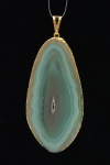 Grande pingente de quartzo verde, encastoado com dourado. 8 x 3,5 cm