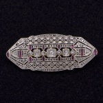 Broche em placa Art Deco, de ouro e platina com diamantes e rubis.  Pt 6.3 grs.  5x2 cm