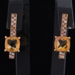 Par de brincos de ouro 18 kts incrustado com 15 brilhantes de aprox 0.2 cts cada e pedra central amarela0,7x0,7 cm.  Comprimento total 2,5 cm.  Pt 4 grs