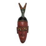 ARTE AFRICANA -  REPÚBLICA DA COSTA DO MARFIM - Antiga máscara antropozoomórfica, etnia Guro, em madeira entalhada e policromada. Exemplar em excelente estado. Dimensões: 42 cm x 13 cm x 11 cm.