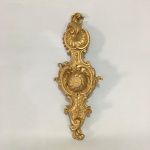 Antigo adorno em metal , estilo Luiz XV, patinado de dourado, decorado com volutas, folhas de acanto e conchas. Dimensões: 40 cm x 15 cm.