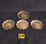 20-Conjunto de quatro lindos porta copos em bronze com desenhos de flores no centro. Sendo 3 medindo 8cm de diâmetro e 1 medindo 10cm