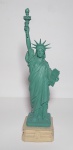 Lindo e antigo suvenir representando a Estátua da Liberdade. Resina.  Medida: 28 X 7,5 X 7,5cm. Possuí assinatura.