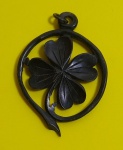 Antigo pingente representando trevo de 4 folhas ,esculpido em material sintético  na cor preta . Medida: 5,5 X 4 cm diâmetro.