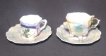 Dois lindos conjuntos em porcelana de xícara para cafezinho, e pires em formato de concha. A menor com pequena perda na borda, conforme foto.  Medidas: pires 10cm xícara maior 6 cm diâmetro. Altura 5 cm.