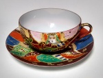 Lindo conjunto de xicara e pires em porcelana oriental, ricamente adornada  em relevo e policromia. Medida: pires 12,5 de diâmetro - xícara - 8,5 de diâmetro X 4,5 de altura.