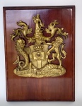 Colecionismo - Heráldica - Curioso, Imponente e decorativo brasão em espessurado metal dourado com inscrições - Sine Praejudicio - Sobre placa de madeira nobre - Medida total: 27 x 19,5 x 4 cm.