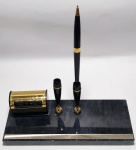 Antigo e lindo calendário permanente (Mês-dia-semana) e porta caneta duplo, com 1 caneta. base em granito - detalhes em metal dourado e plástico rígido. Medida sem a caneta: 23 cm comp x 9 cm larg . OBS: Na parte de trás do calendário, possui arranhões no metal.