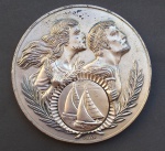 MEDALHA EM METAL PRATEADO - Pizza - Anverso estampa em relevo com gravuras de Veleiros - Reverso gravado 1 Lugar C.C. Castelo - Clube de Campo Castelo - Mede: 60mm de diâmetro X 5 mm espessura.