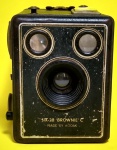 Rara Máquina fotográfica Modelo: SIX 20 - Brownie C - Made By Kodak - Estrutura em metal e couro - Medida: 11,5 x 10 x 7,9 cm.