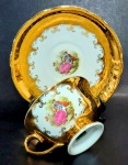 DANIELE MILIONE - Xícara de chá e respectivo pires decorados por cena galante em policromia e farta pintura em ouro. Mede 5,5 x 9,5 cm a xícara e 14,5 cm de diâmetro o pires.