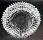 Grande cinzeiro em bloco único de cristal translúcido dito `Maracanã` decorado por corpo e borda serrilhados de lado a lado. Mede 3,5 cm de altura por 14 cm de diâmetro.