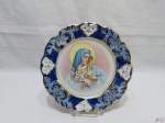 Lindo prato decorativo em porcelana com imagem de Nossa Senhora, borda com relevos. Medindo 22,5cm de diâmetro.