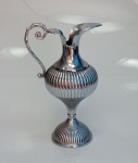 Belíssima ânfora em metal espessurado à prata, com decoração em gomos, medindo 34 cm x 22 cm.