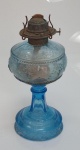 Belíssimo lampião à querosene em vidro na cor azul, apresentando trincado no bojo. Não acompanha manga. Mede 28 cm x 13 cm.