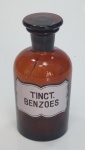 Belíssimo pote de farmácia na cor âmbar com a inscrição TINCT BENZOES. Apresenta tampa lacrada e fio de cabelo no gargalo, medindo 15 cm x 7 cm.
