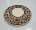 Jogo para bolo com 7 peças em porcelana da marca Grindley England com decoração em flores e frisos. Mede a maior peça 25 cm diâmetro. Apresentam marcas do tempo e dois pratos com bicados.
