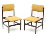 Design. Par de cadeiras em jacarandá em linhas retas dos anos 60. Guarnições de sustentação do encosto em metal. Assento e encosto forrados em tecido bege escuro.