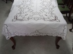 ILHA DA MADEIRA  Toalha de mesa em linho na cor branca com bordados em branco em cheios, rechelier, garanitos, ilhós e caseados, medindo 2,58 m x 1,60 m.