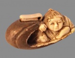 Gyokushi (atribuído). NETSUKE em marfim representando criança com canoa , assinado na base. Med. 6 cm