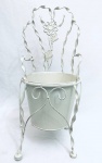 Suporte para vaso de planta, em formato de cadeira, em metal, decorado com borboletas e flores em relevo. Med. 48x26 cm. Diâm. do suporte de vaso: 18,5 cm.