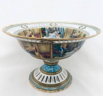 Belíssimo centro de mesa em porcelana azul e branca, decorado com cenas de época, arabescos e desenhos em ouro, borda e base com detalhes vazados. Med. Diâm. 30,5 cm. Alt. 18 cm.