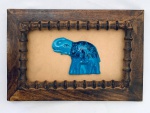 Quadro com moldura em madeira, decorado com figura de elefante em cerâmica na cor azul. Med. 25,5x38 cm.