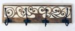 Cabideiro em madeira nobre, decorado com entalhes de arabescos, com quatro ganchos em ferro. Med. 45,5x13 cm.