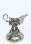 Molheira com suporte, pedestal, guarnecida por volutas e arabescos, em metal. Med. 19x22 cm.