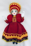 Boneca em porcelana e tecido. Med. Alt. 31 cm.
