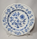 MEISSEN - Prato em porcelana alemã, da manufatura Meissen, padrão dito cebolinha em tom azul e bordas onduladas sobre fundo branco. Med. 24,5 cm.