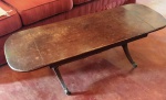 Antiga mesa de centro em madeira maciça com pontas dobráveis e pés de ferro com terminais de patas de leão . Mede: 120 x 40 x 40 cm 