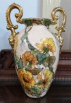 Grande vaso anfora  em porcelana com rica policromia floral e detalhes em dourado. Possui restauro em um dos braços . Mede: 42 x 24 cm 