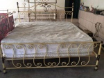 Antiga cama em ferro dourado com dobramento ricamente ornamentada. Com colchão . Mede: 220x200 cm .
