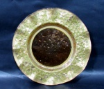 VIDRO - Um prato decorativo confeccionado em vidro, bordas moldadas em forma embabadada, decoradas com pintura brilhosa vastamente dourada, com lapidação de "ovinhos" . Medidas diam 24 cm x 24 cm.