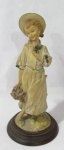 ESCULTURAS - Escultura em resina italiana representando "Florista", ricamente detalhada e policromada, sobre base de madeira torneada, medidas alt 25 cm x diam da base 12 cm.