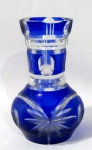 CRISTAIS - Um vaso decorativo em cristal double azul, bojudo, com gargalo cônico, decorado com rica lapidação de ranhuras, sulcos, dedão e palmas, fundo estrelado. Medidas alt 12,5 cm x diam 5 cm.